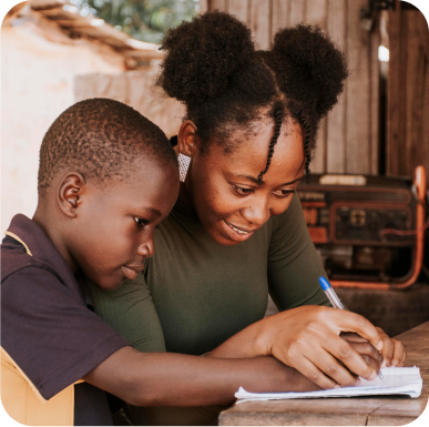 Lady teaching child to write on a book while holding her hand